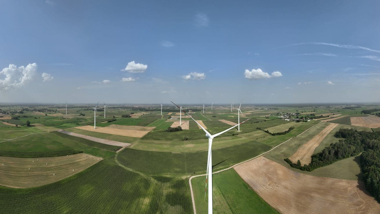 Turbina wiatrowa na tle pól z lotu ptaka